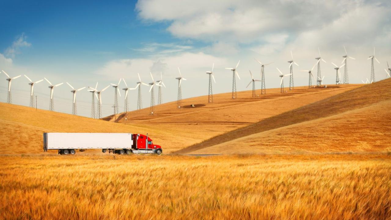 truck along hillside with wind turbines
