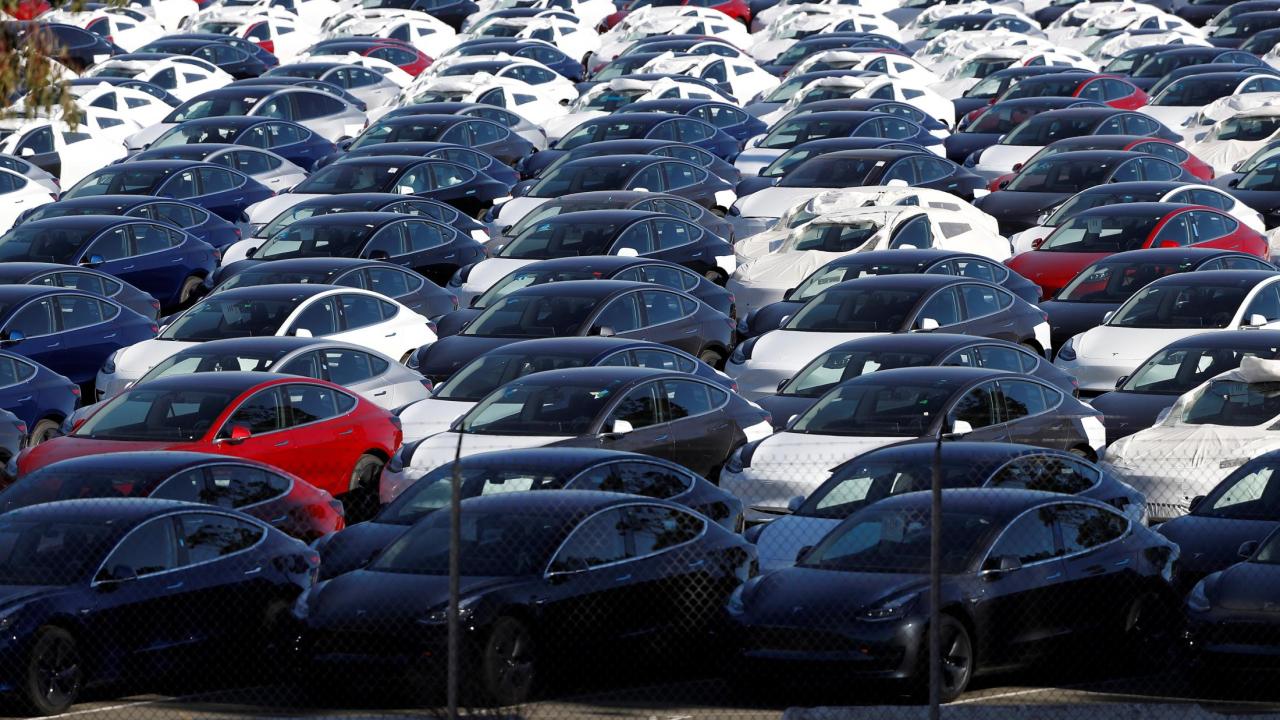 Parking lot containing compactly parked Tesla Model 3s of various colors