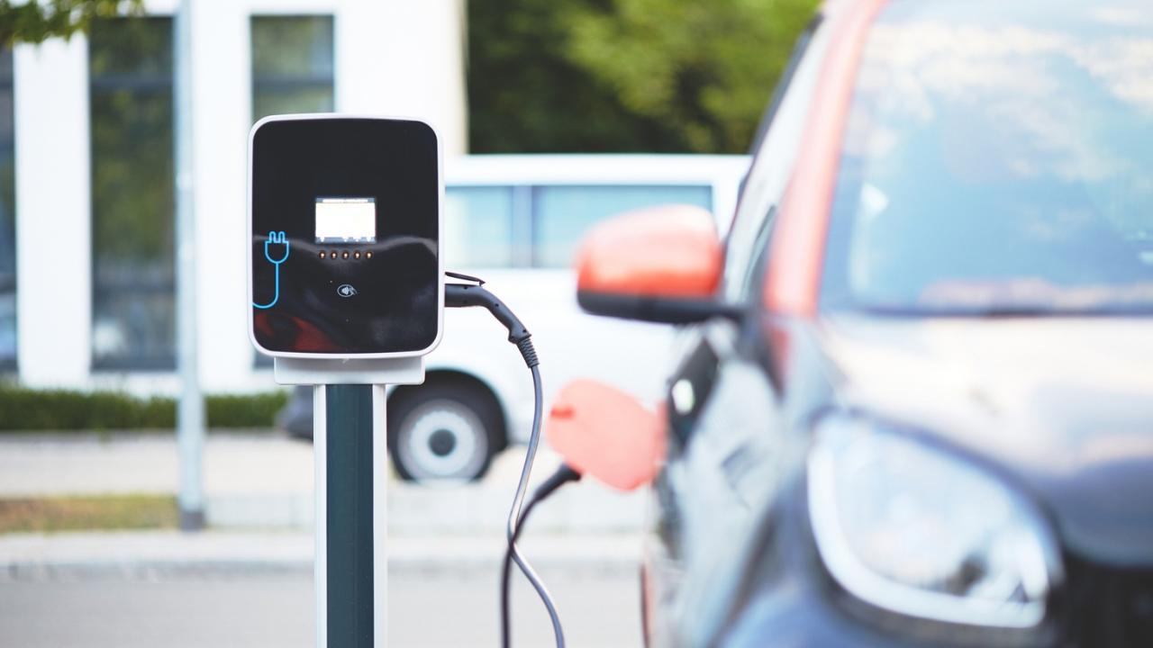 Electric vehicle plugged into charging station